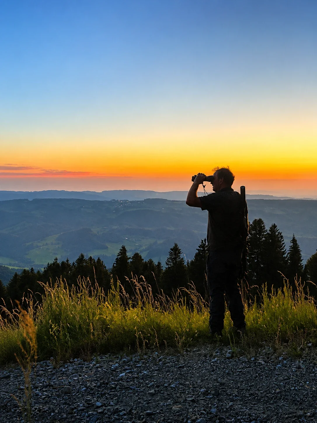 Jäger beobachtet das Allgäuer Panorama bei Sonnenuntergang vom Hochgrat